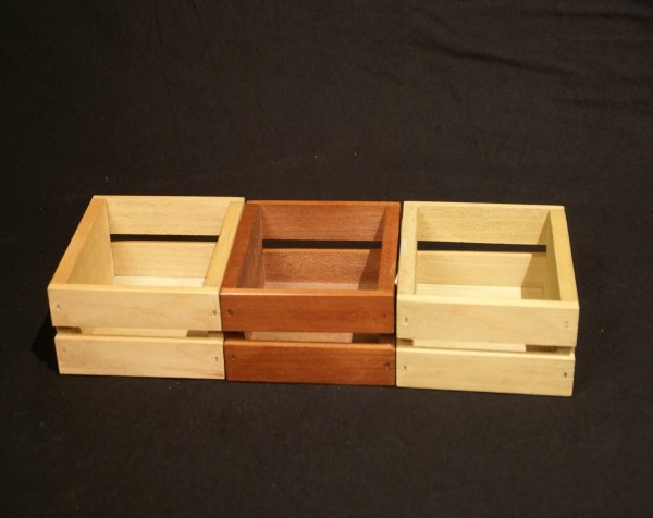 Three small open-top custom wooden crates, available in bulk for product packaging, retail display, and promotional branding. One example is stained.